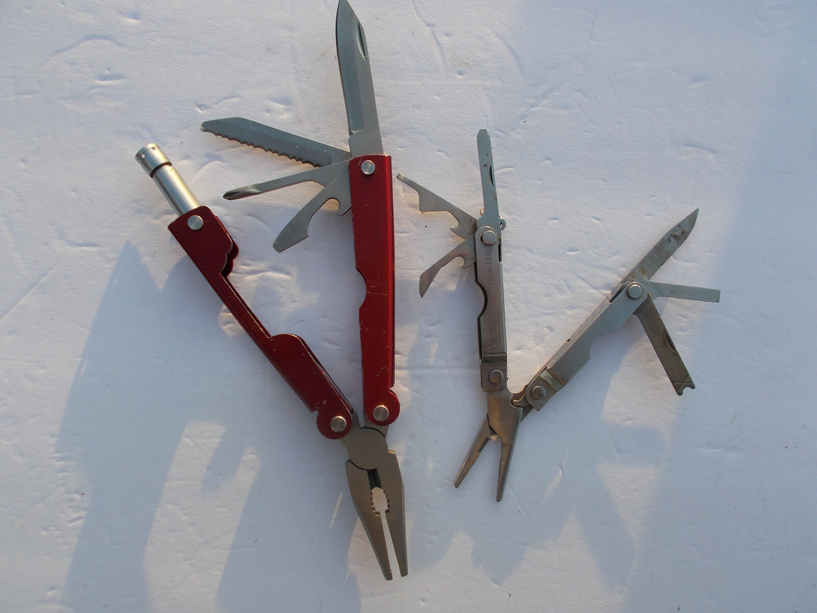 Lot of (2) multi tools – 1 Durex advertising silver tone and 1 unbranded red
