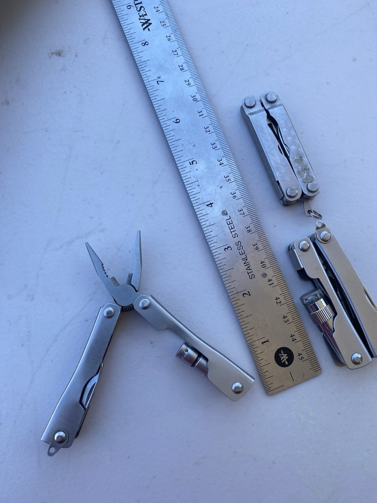 Lot of 2 Multitools w/ pliers blade file saw flash light scissors etc.