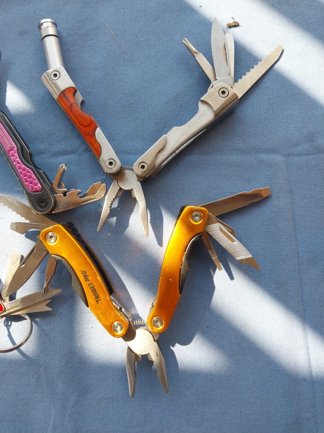 4 multi tools with pliers knives screwdrivers saw