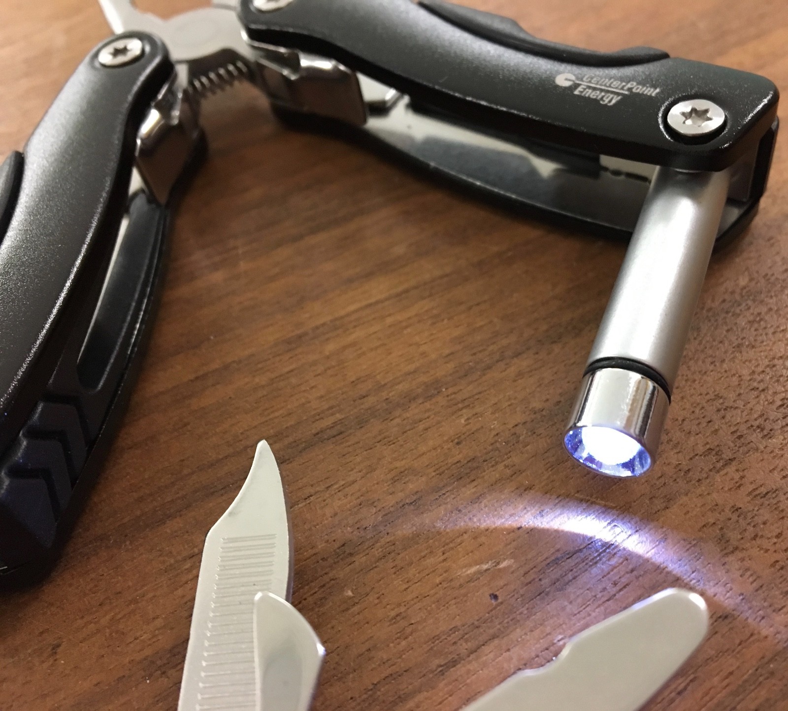 Pair of multi tools, one blue, the other black, with sheaths. Camp, hunt, crafts