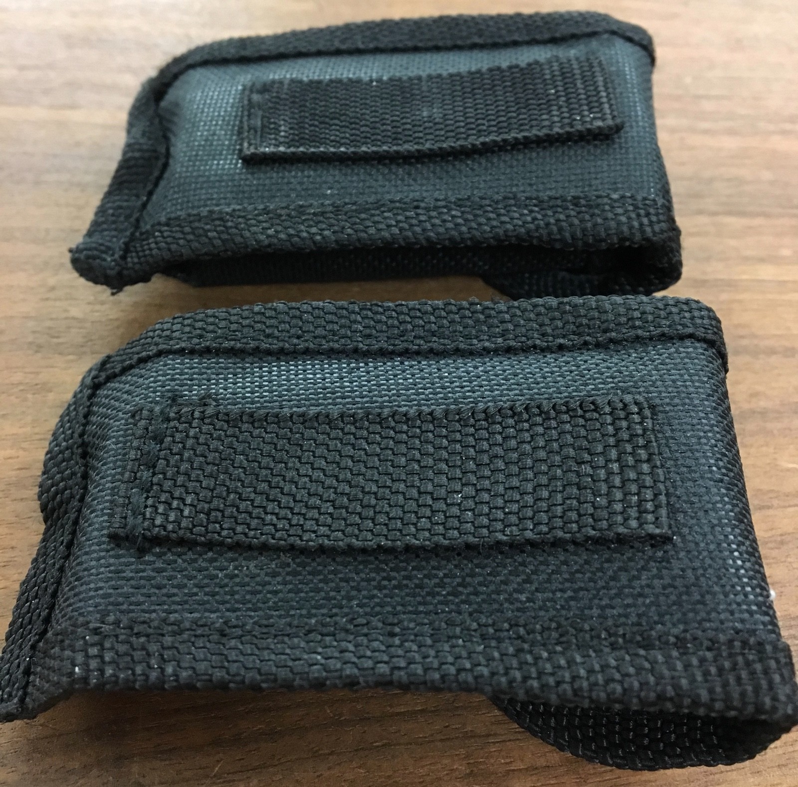 Pair of multi tools, one blue, the other black, with sheaths. Camp, hunt, crafts