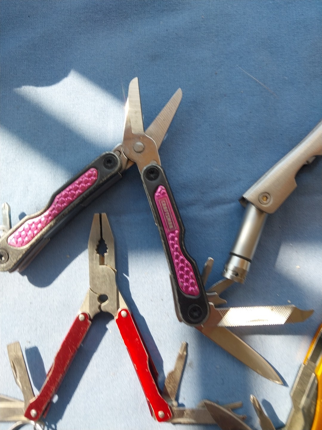 4 multi tools with pliers knives screwdrivers saw