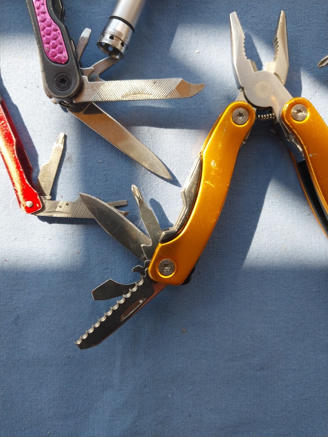 4 multi tools with pliers knives screwdrivers saw
