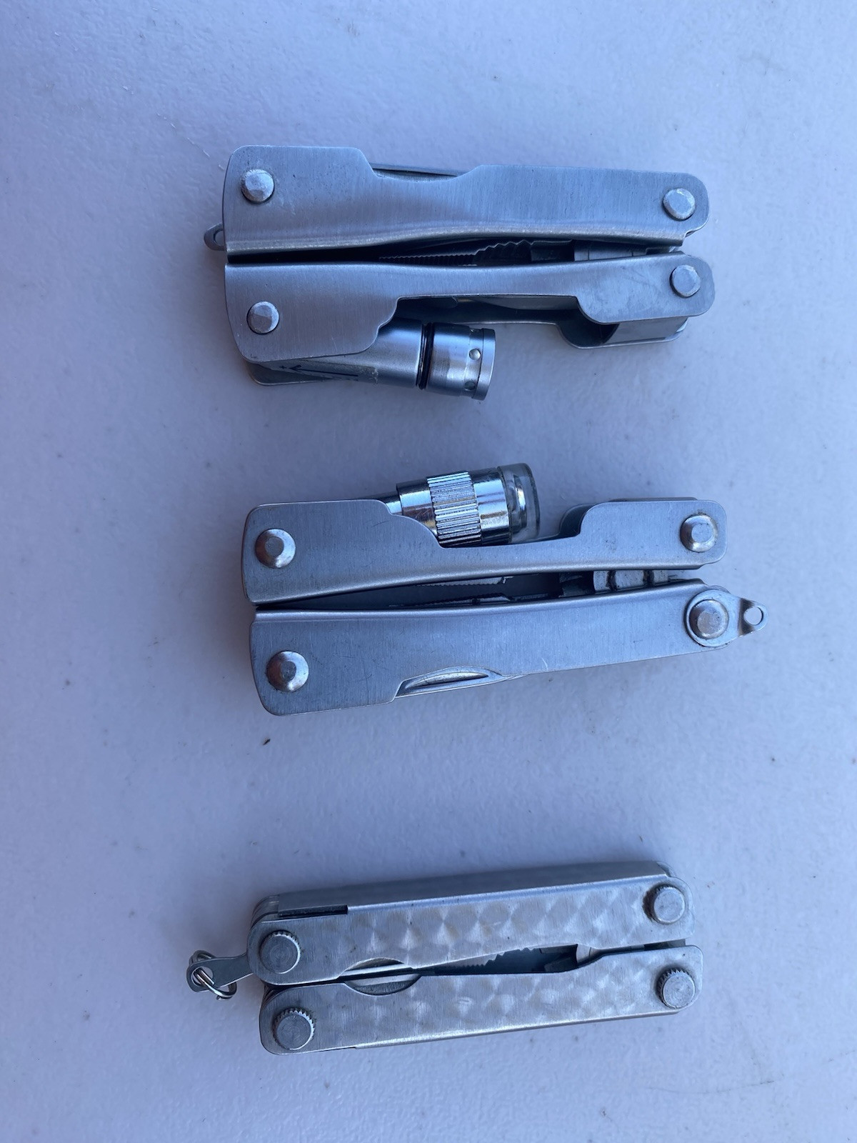Lot of 2 Multitools w/ pliers blade file saw flash light scissors etc.