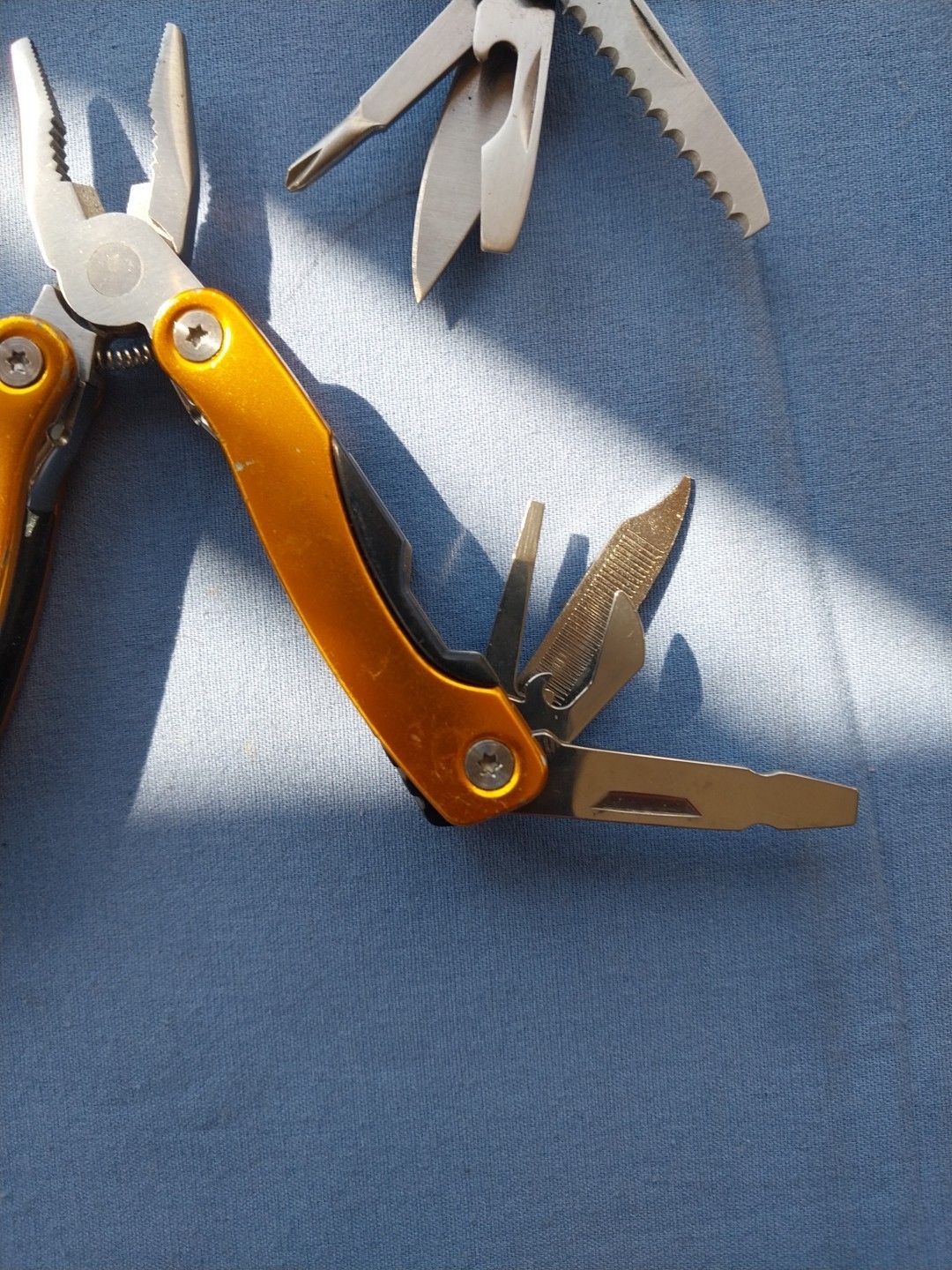 4 multi tools with pliers knives screwdrivers saw