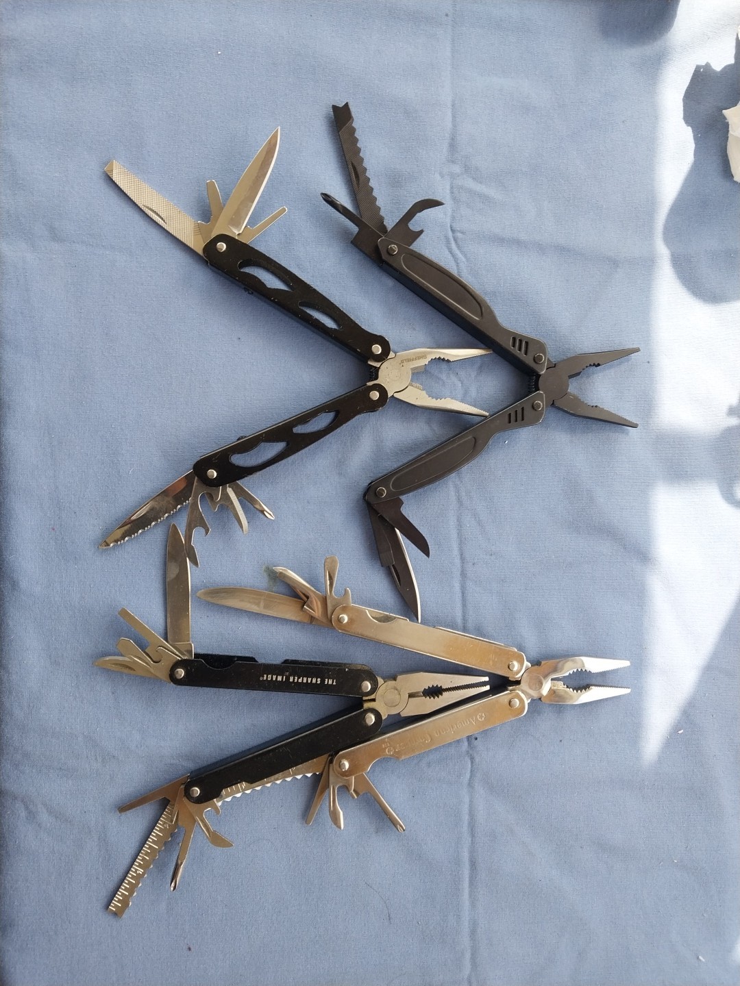 4 multi tools with pliers knives screwdrivers saw