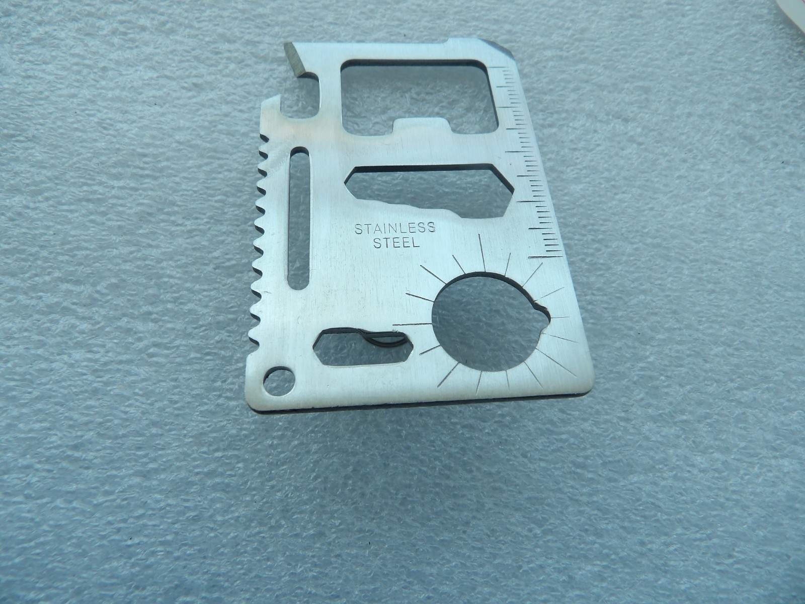 Wallet-sized stainless steel multi-tool with 11 different functional features