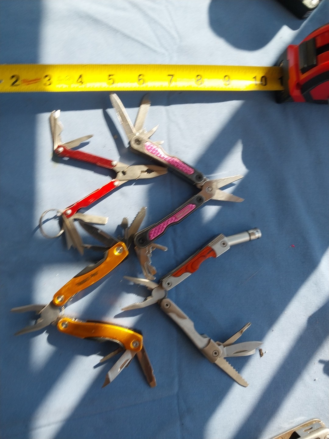 4 multi tools with pliers knives screwdrivers saw