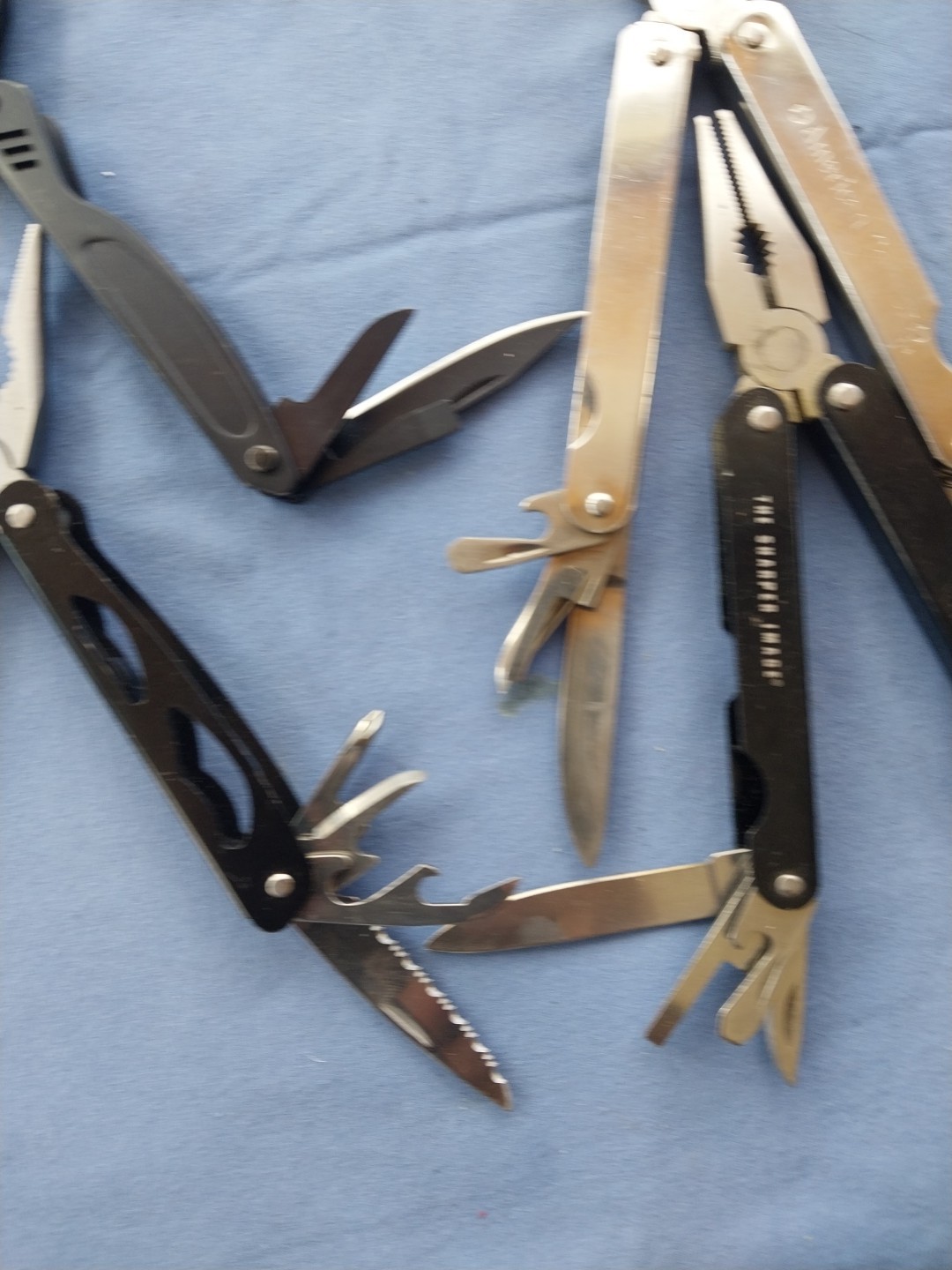 4 multi tools with pliers knives screwdrivers saw