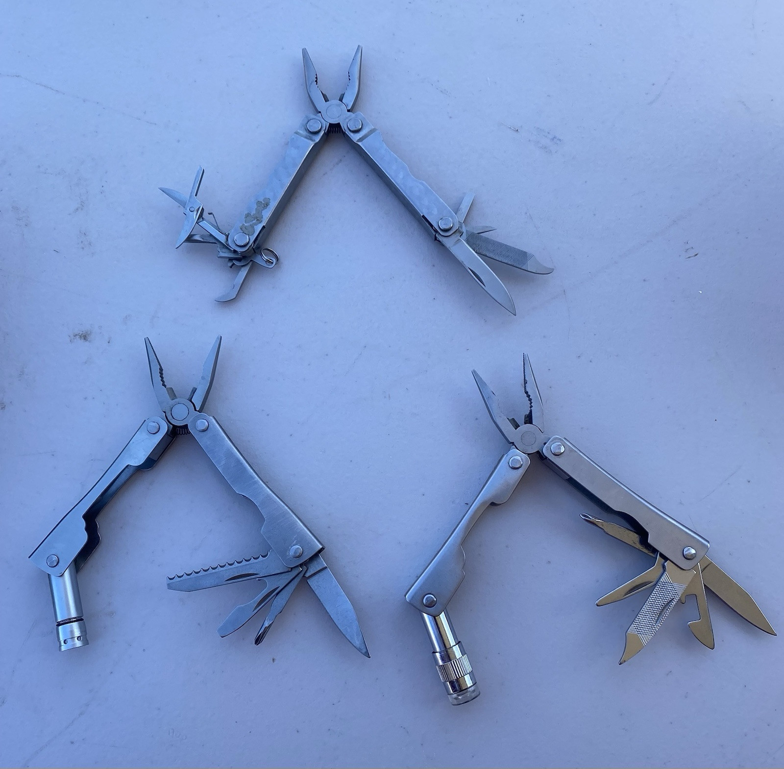 Lot of 2 Multitools w/ pliers blade file saw flash light scissors etc.
