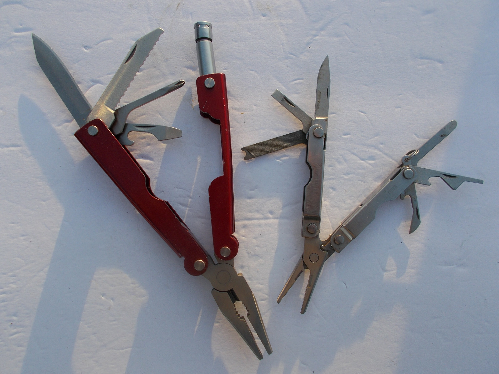 Lot of (2) multi tools – 1 Durex advertising silver tone and 1 unbranded red