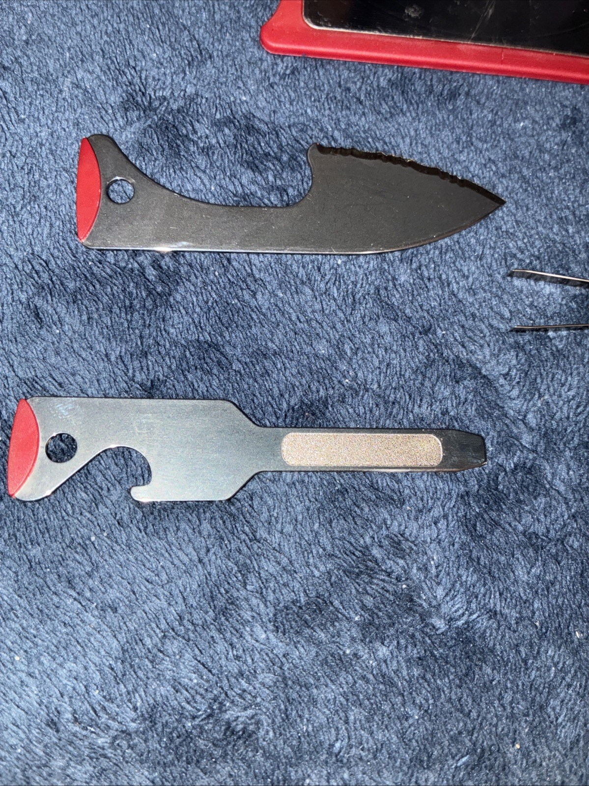 Red credit card size multitool has knife, toothpick, tweezers, and other Items