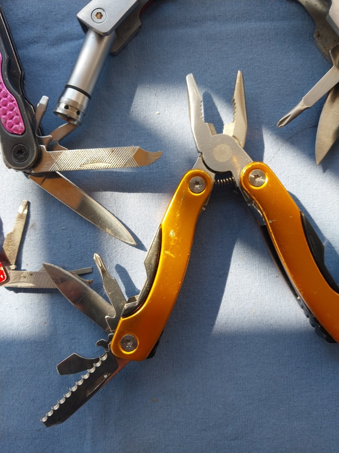 4 multi tools with pliers knives screwdrivers saw