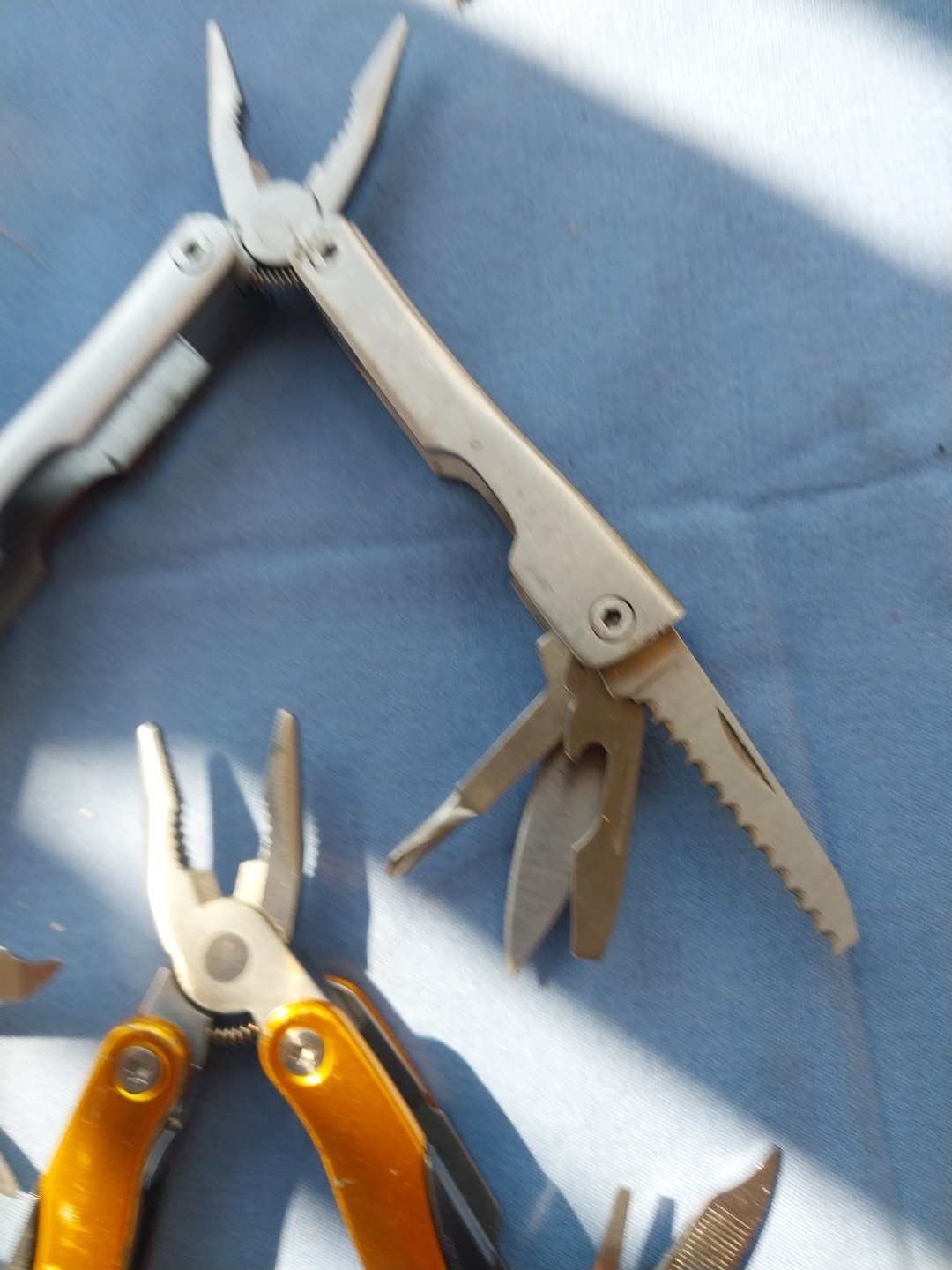 4 multi tools with pliers knives screwdrivers saw