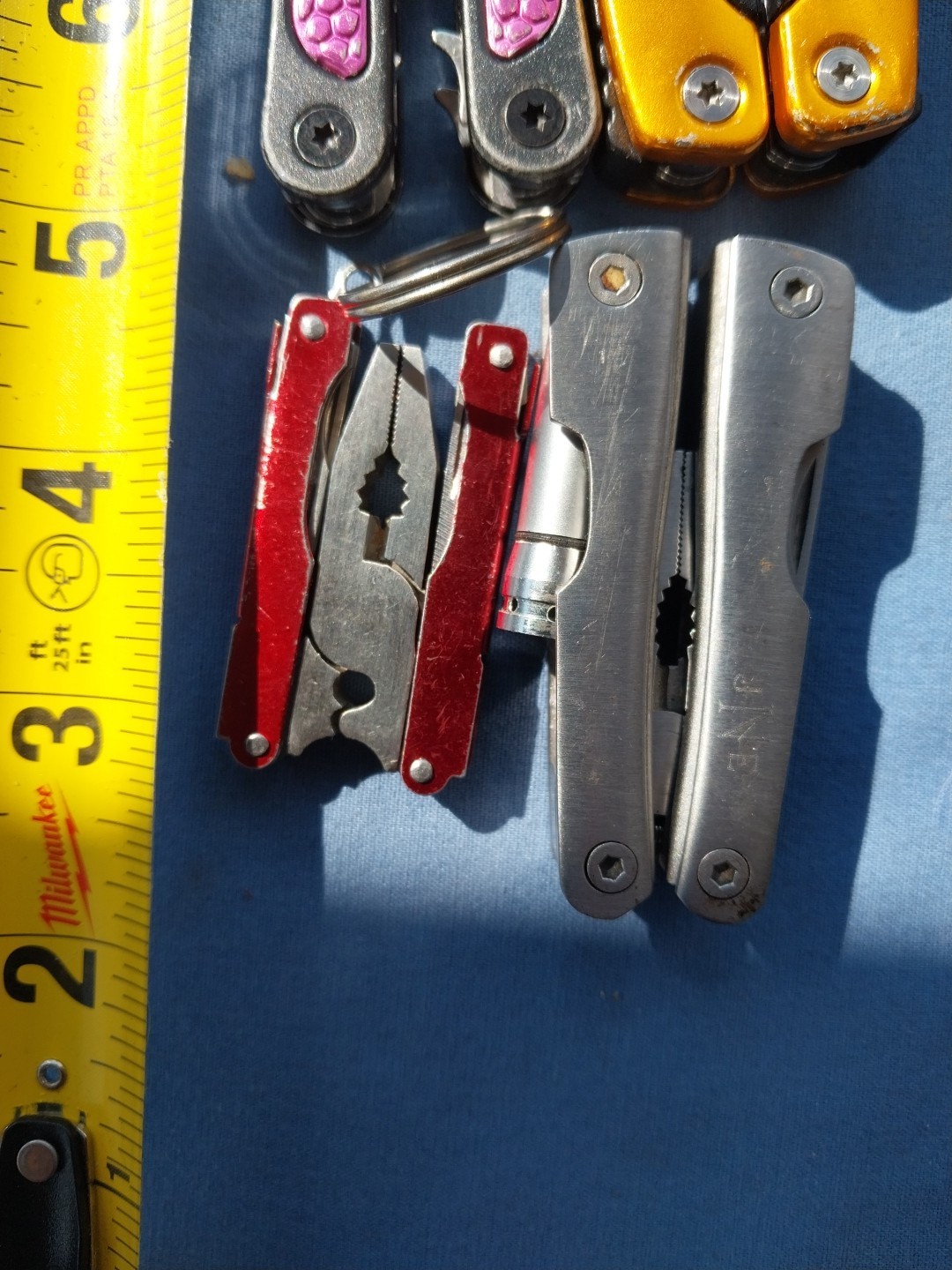 4 multi tools with pliers knives screwdrivers saw