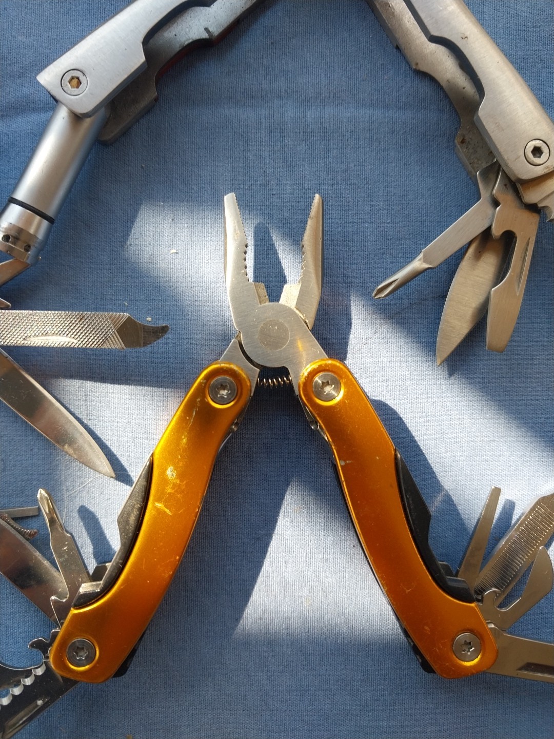 4 multi tools with pliers knives screwdrivers saw